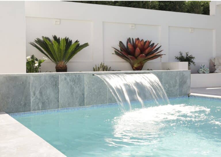 Custom concrete pool in Illawong with a feature wall and sheer descent waterfall