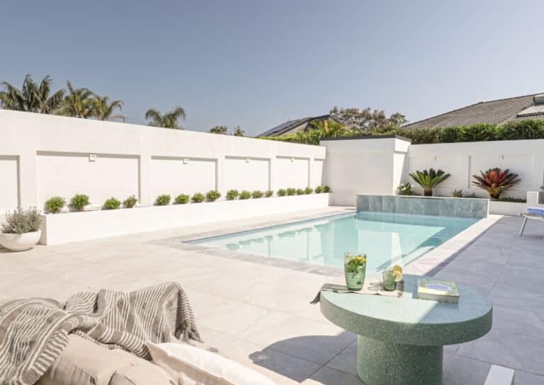 Mediterranean concrete pool with sun lounge area and clean outdoor design, custom built in NSW by Blue Haven Pools