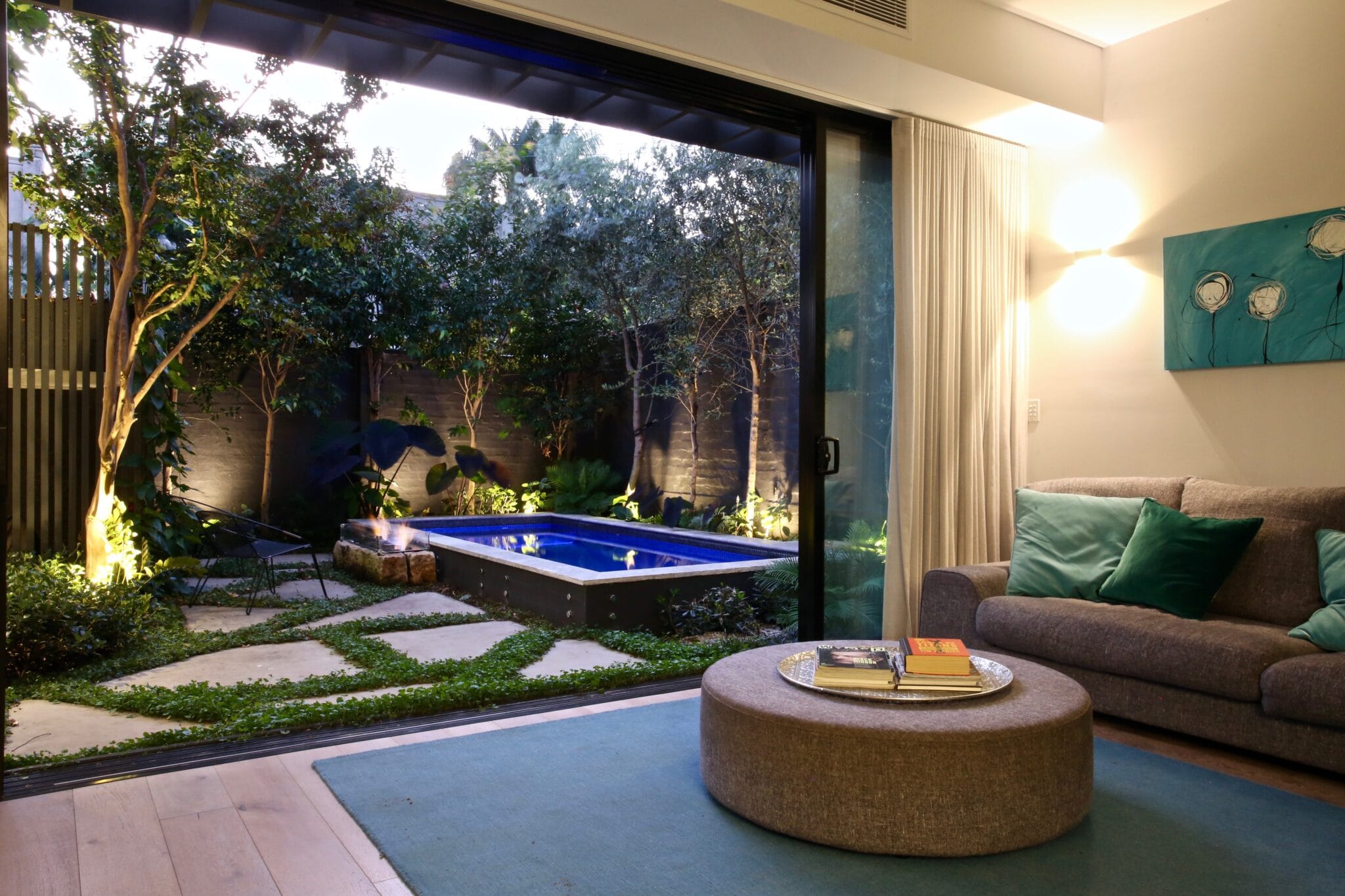 Architectural concrete pool in Bondi Junction, illuminated at night and designed for refined urban outdoor living, by Blue Haven Pools.