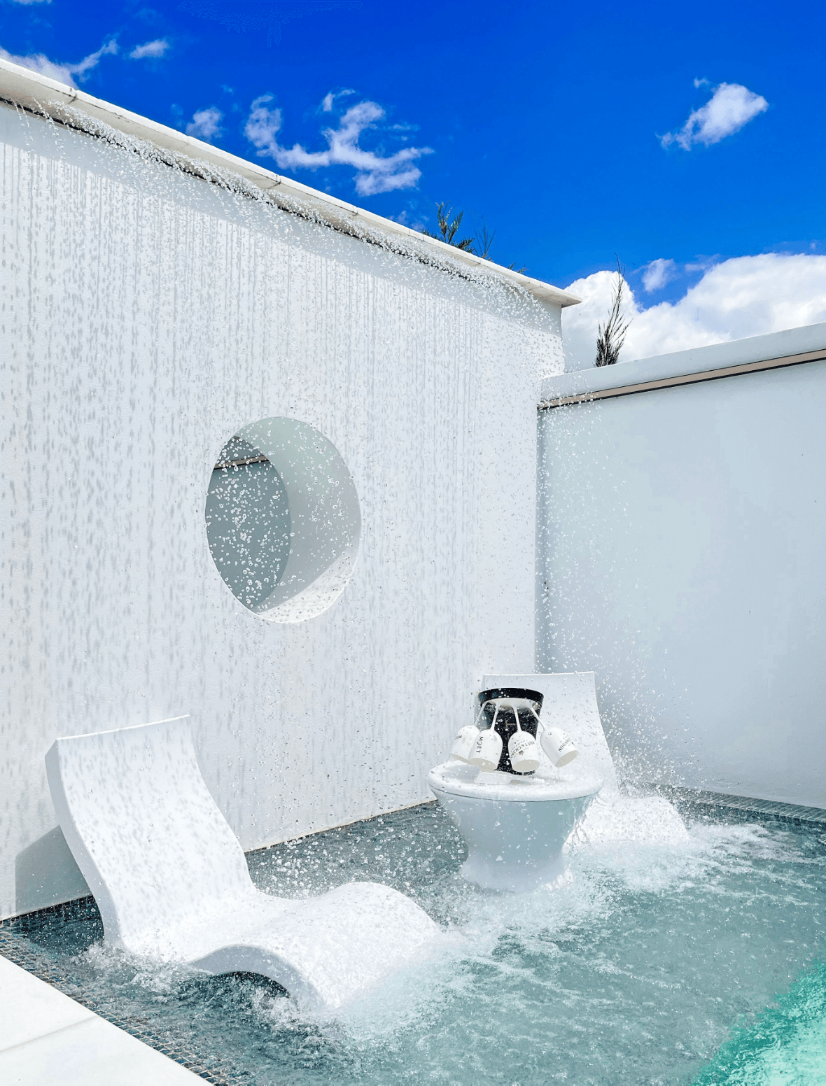 Luxury concrete pool with a custom feature wall and cascading water feature