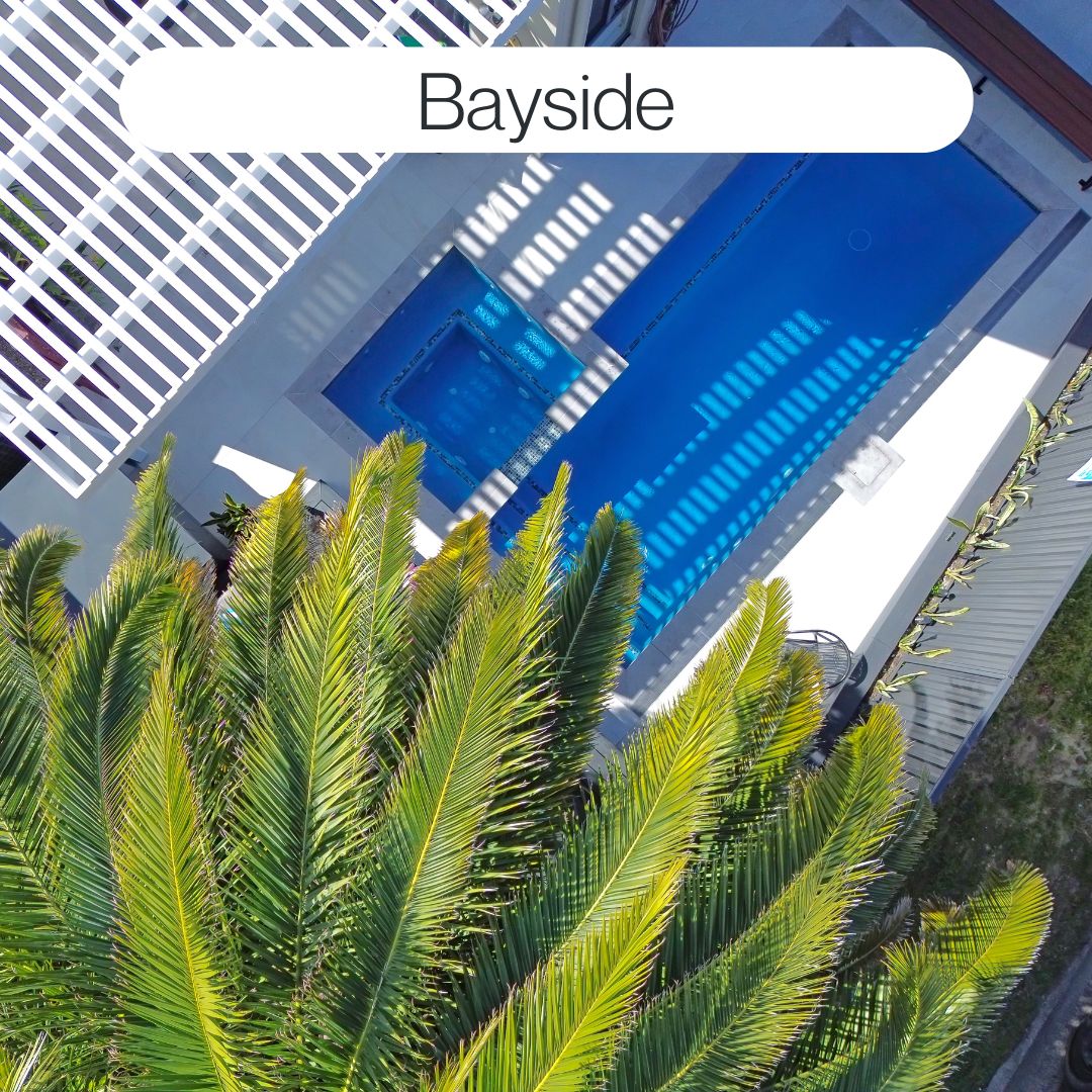Aerial view of a custom swimming pool and spa in Bayside with tropical landscaping, modern paving and private backyard design