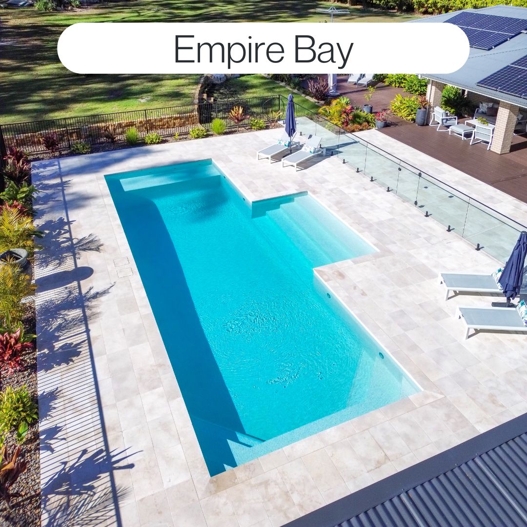 Modern backyard swimming pool in Empire Bay with glass fencing, large paved surrounds, sun lounges and outdoor entertaining space