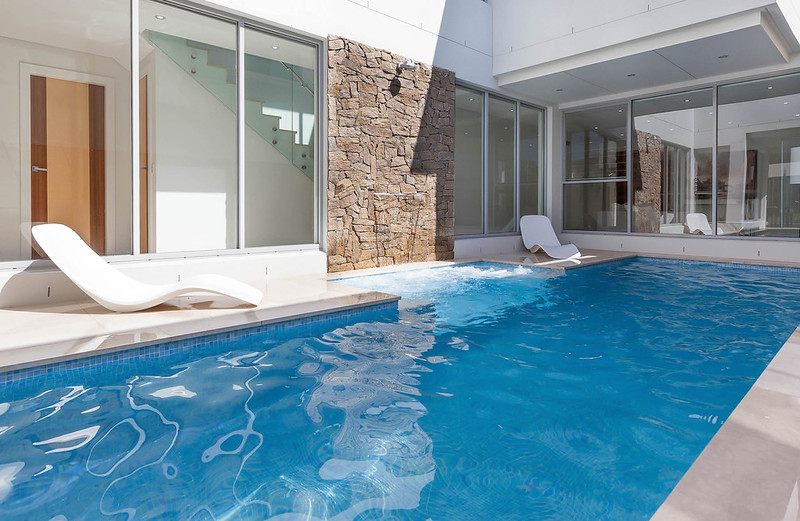 Modern backyard pool design in South Hurstville connecting lap pool, stone feature wall and outdoor living area