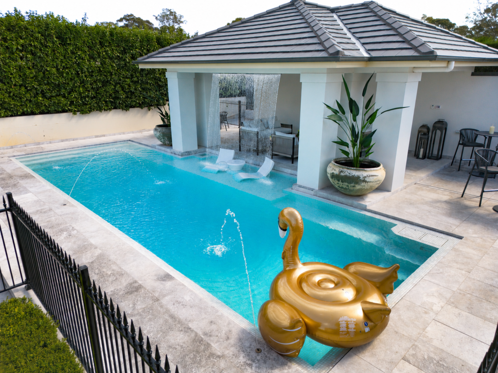 Blue Haven Pools concrete pool with a cabana and sheer descent waterfalls in Catherine Fields