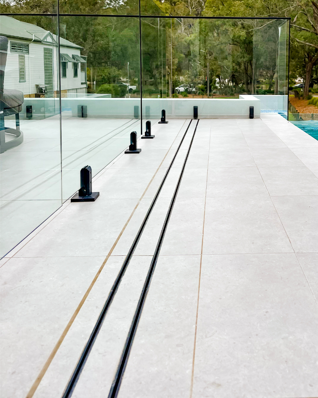Linear drain integrated into a modern swimming pool surround