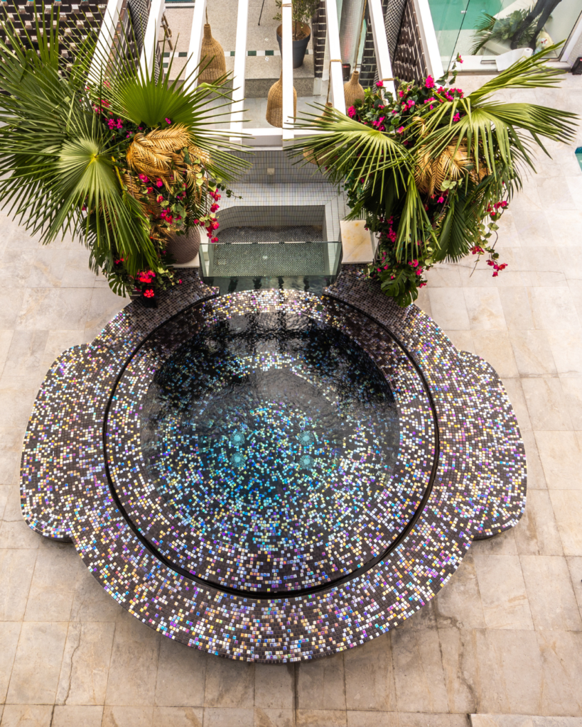 Fully tiled spa integrated with a modern concrete swimming pool.