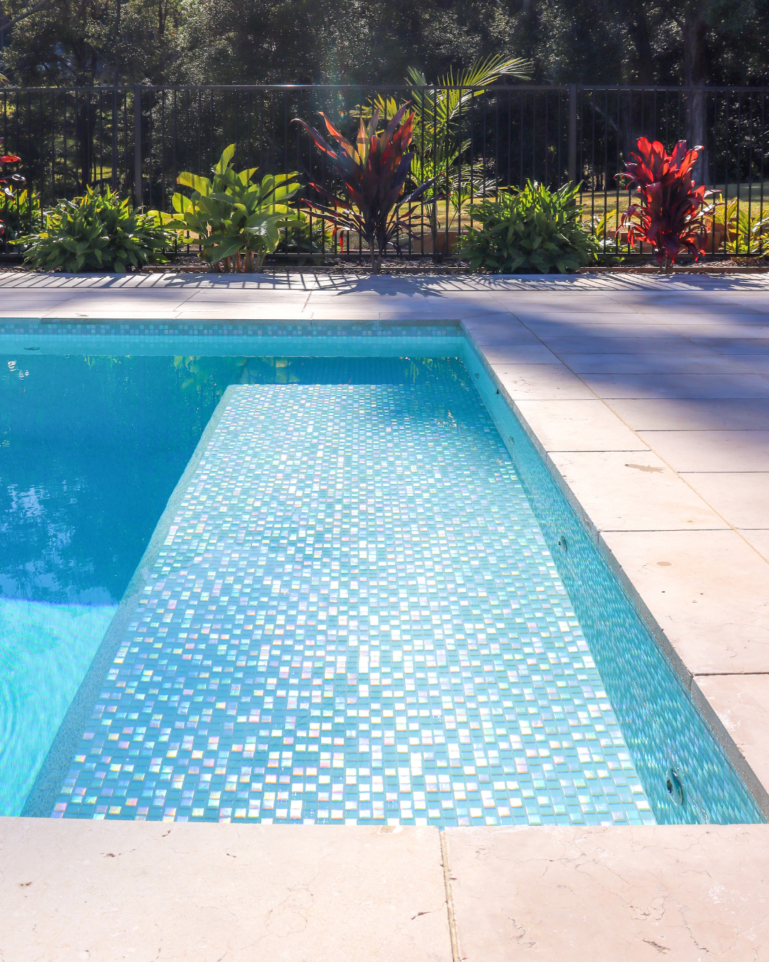 Swimming pool ledge tiles incorporated into a modern concrete pool design