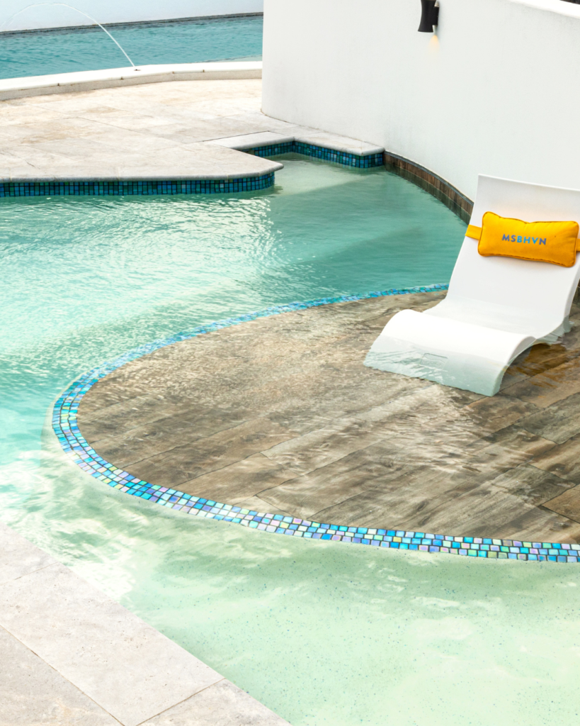 Contemporary swimming pool with a tiled wet deck and shallow lounging area.